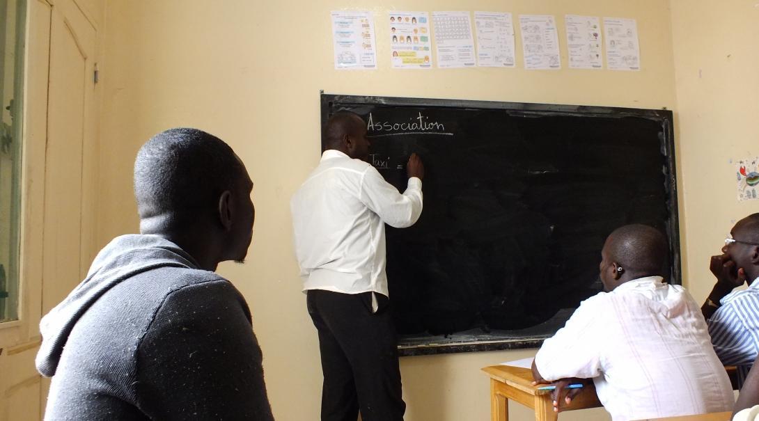 A Projects Abroad volunteer hosts a class in Senegal. A teaching volunteer write on the board during a lesson in Senegal.